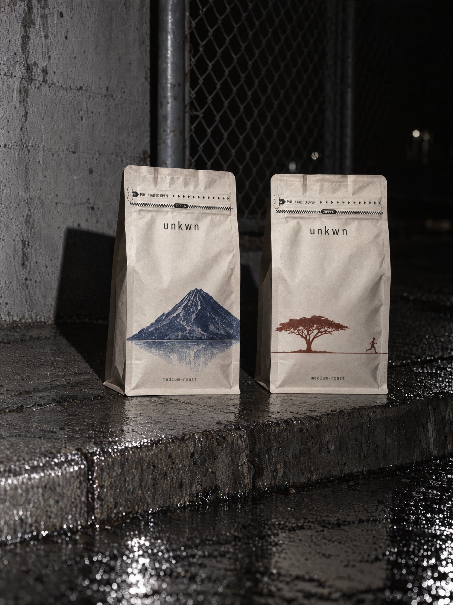 Two unkwn bags on a wet concrete kerb at night, hard flash