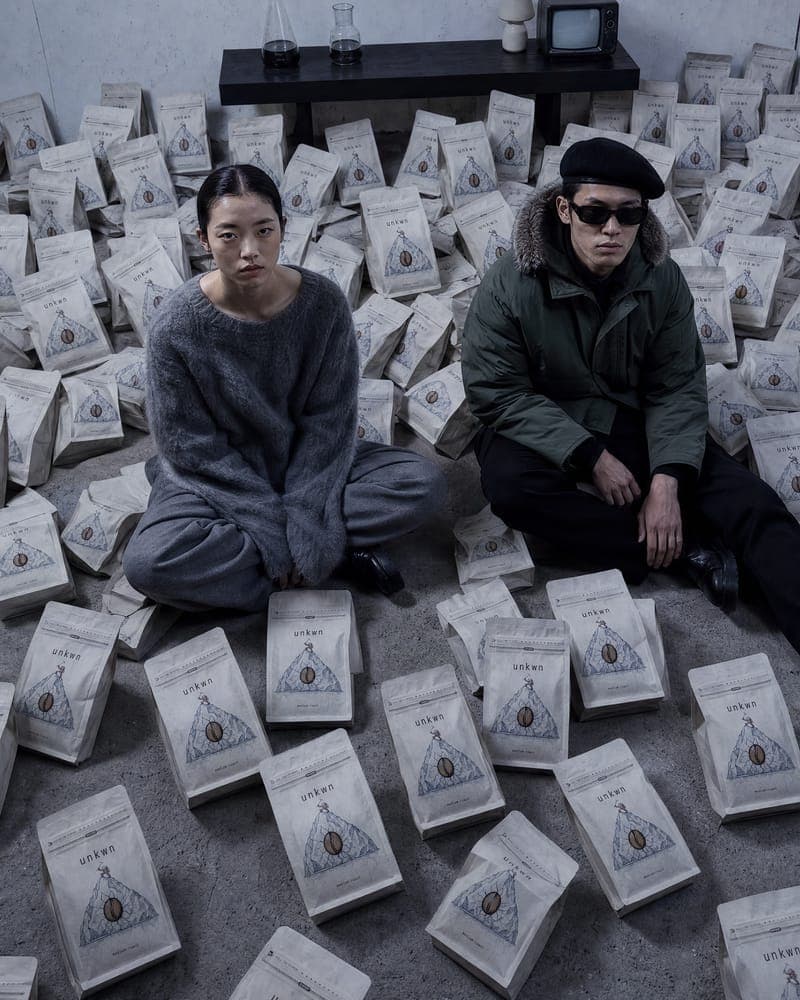 Two figures seated among bags, campaign still